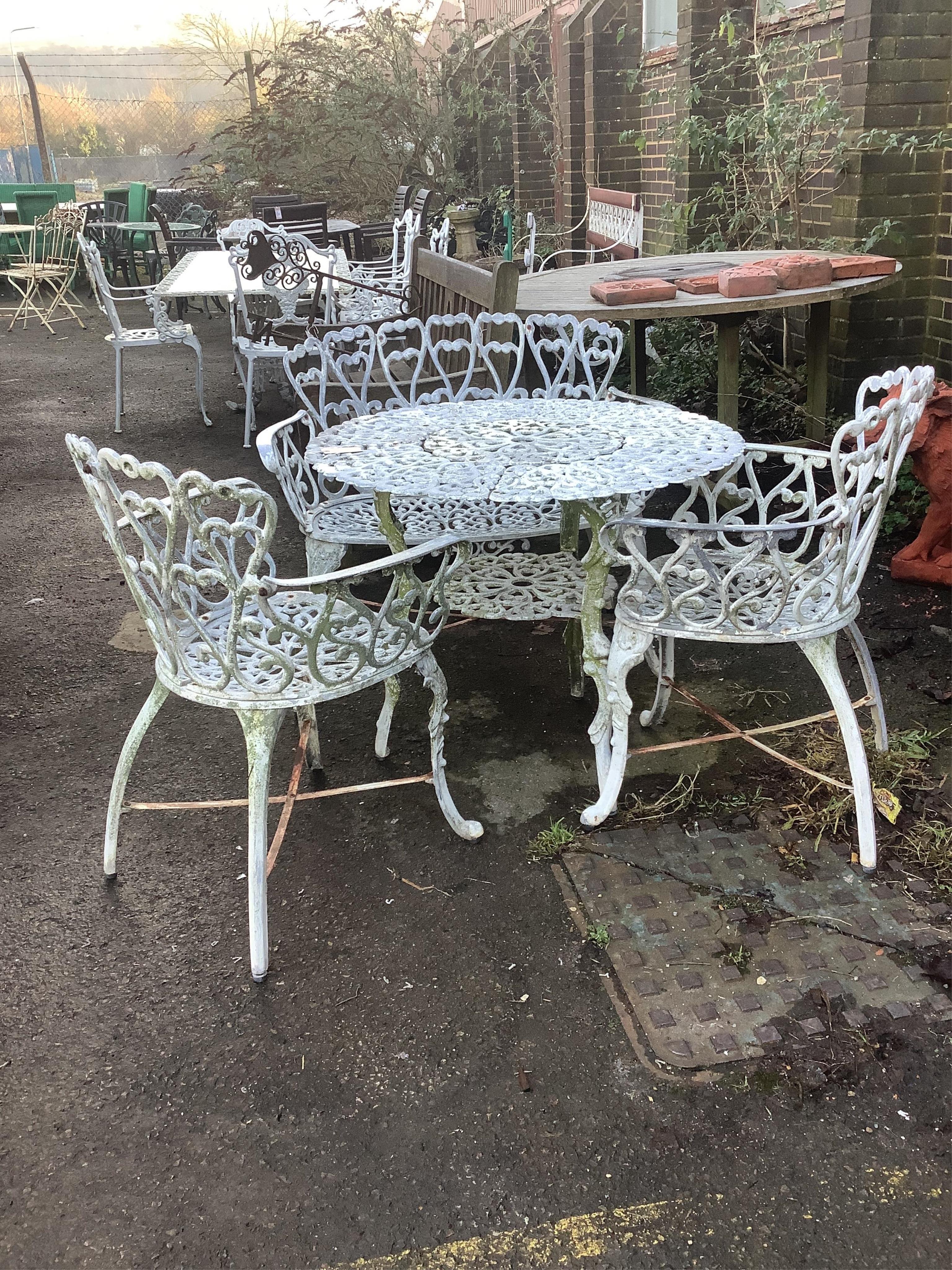 An aluminium garden table, diameter 80cm, height 66cm with two chairs and a bench. Condition - fair